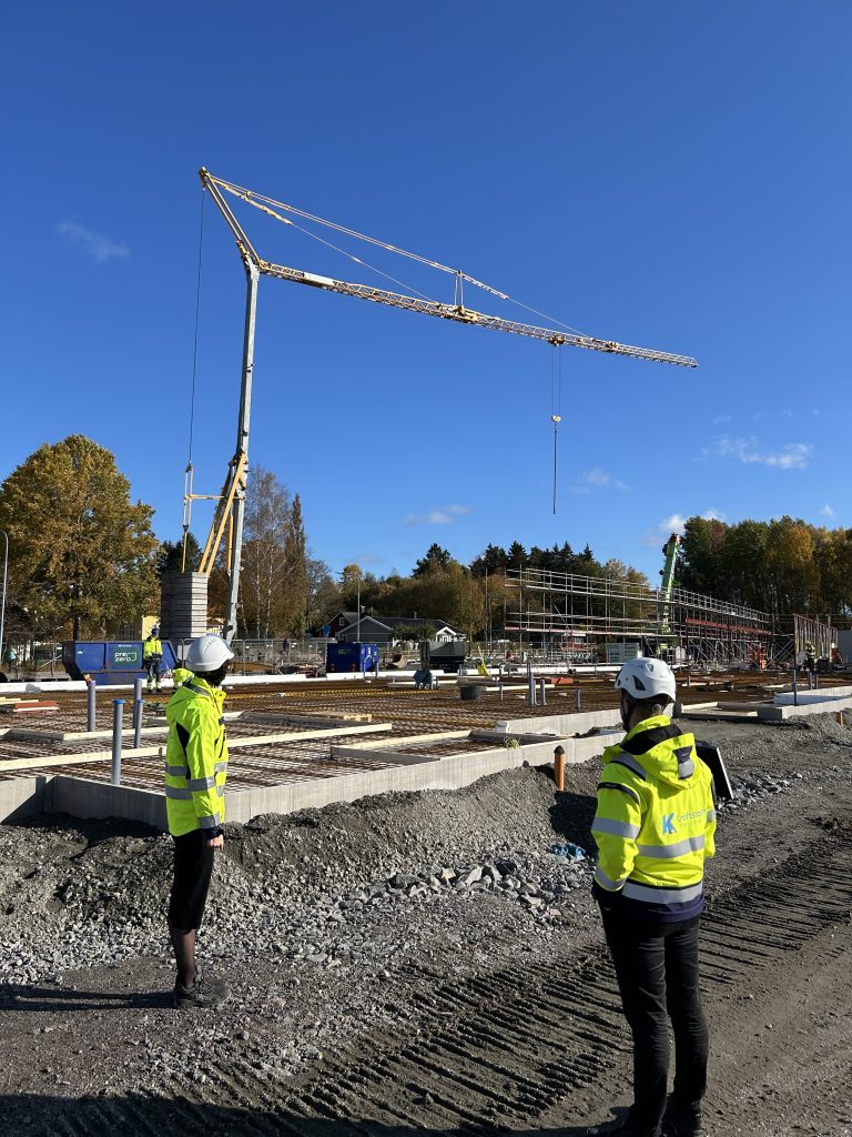 En man och en kvinna i varselkläder tittar på bottenplattan.