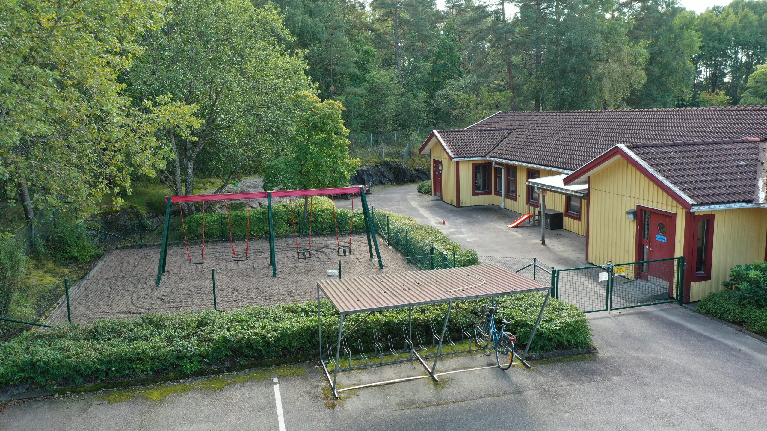 Gungställning och cykelställ framför förskolan Blåvingen. 