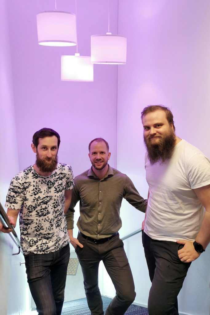 Patrik Birgersson, Marcus Munther och Patrik Elg står i entrétrappan som har lila belysning