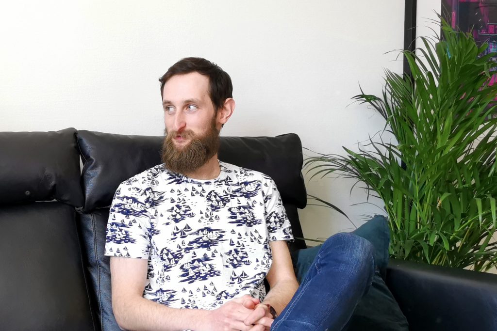 Patrik Birgersson helt själv på bilder tittar till höger med ett leende.